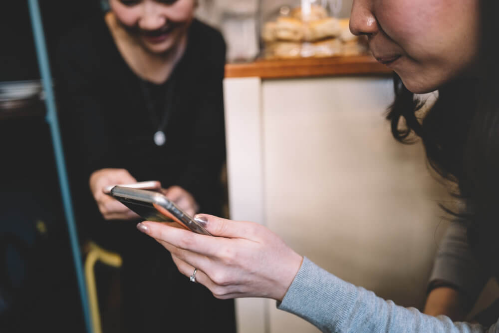 Women sharing information on their phones.