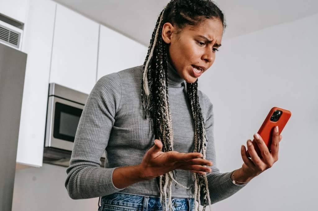 A woman angrily stares at her smartphone